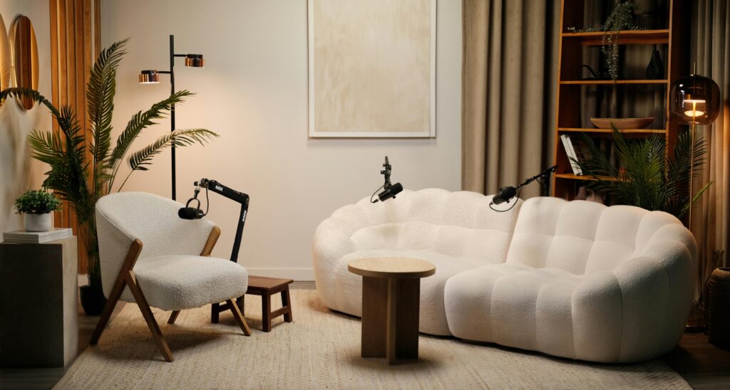 Modern podcast studio featuring white boucle furniture and warm wood accents in Montreal.