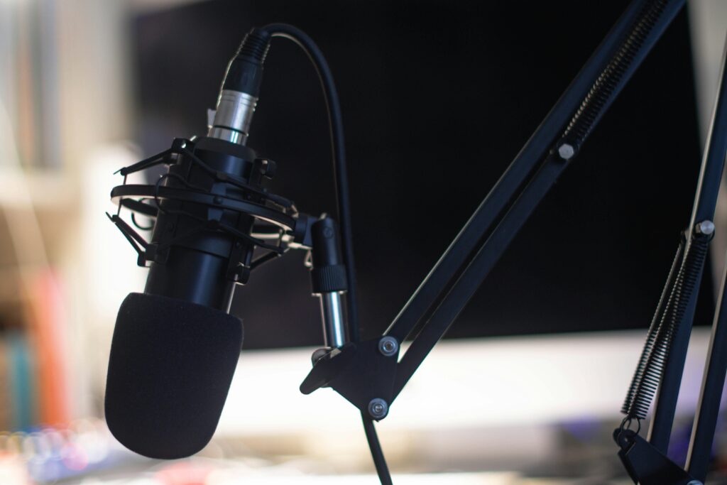 Close-up of a condenser microphone in a studio setting, ideal for podcasts and audio recording.