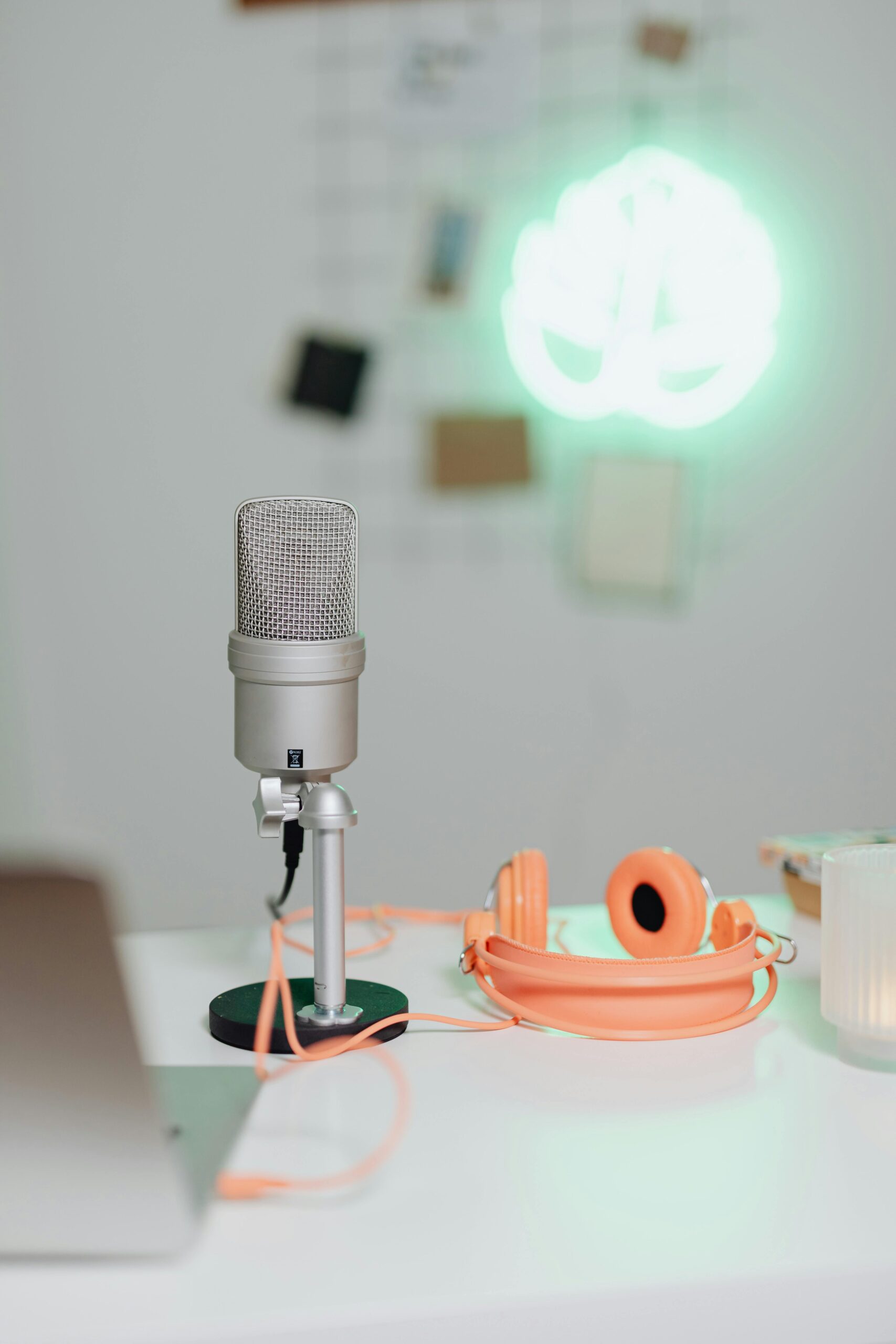 Simple home audio setup featuring a microphone, headphones, and soft lighting for creative projects.